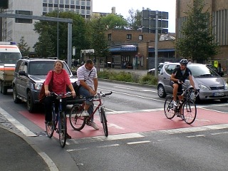 Radfahrer stehen vor Autos