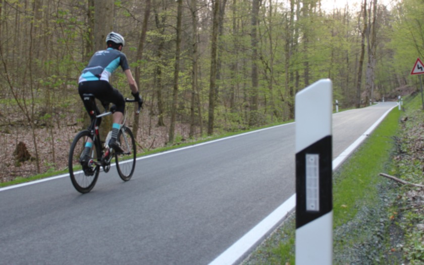 Radsportler auf der Straße durch den Krofdorfer Forst zwischen Lollar-Salzböden und Krofdorf-Gleiberg im Jahr 2023