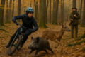 Eine Jägering beobachtet eine Mountainbikerin, die einem Wildschwein und einem Reh ausweicht. Symbolfoto: KI-generiert, chatgpt.com